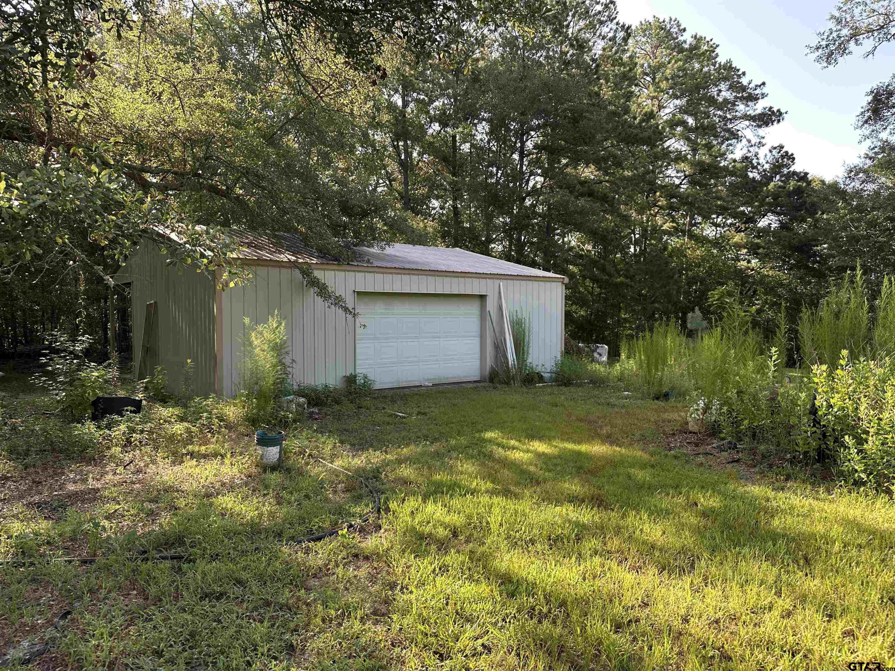 109 South Shell Street Overton, TX 75684 - Photo 2 of 12 a backyard of a house with plants and large tree