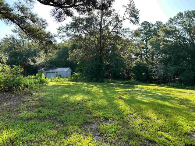 a view of yard with swimming pool and trees