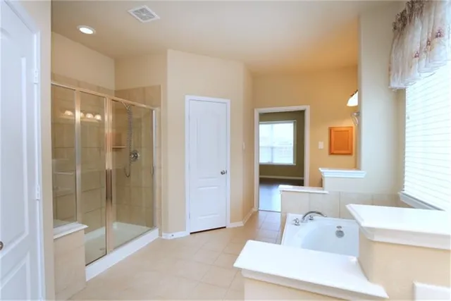 a spacious bathroom with a bathtub and a shower