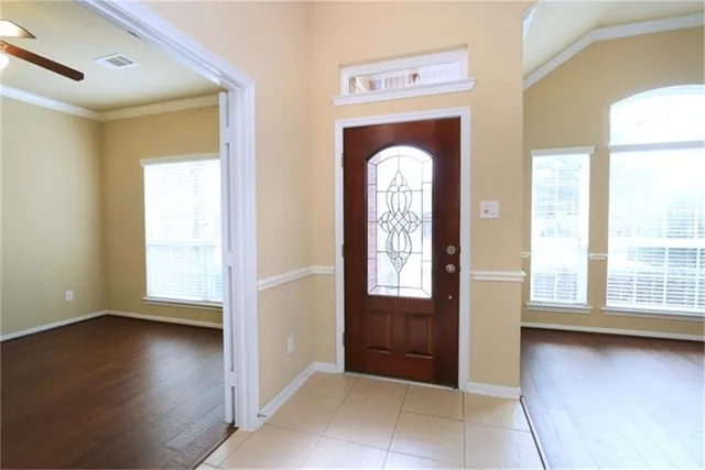 a view of an empty room with a window and wooden floor