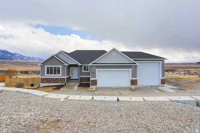 1981 West Ridgeline Road Stockton, UT 84071 - Photo 1 of 1 Craftsman-style home with a mountain view, stone siding, driveway, and an attached garage