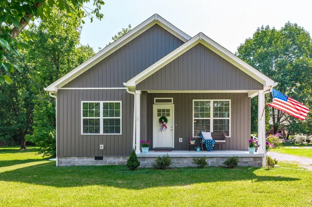 a front view of house with yard outdoor seating and garden
