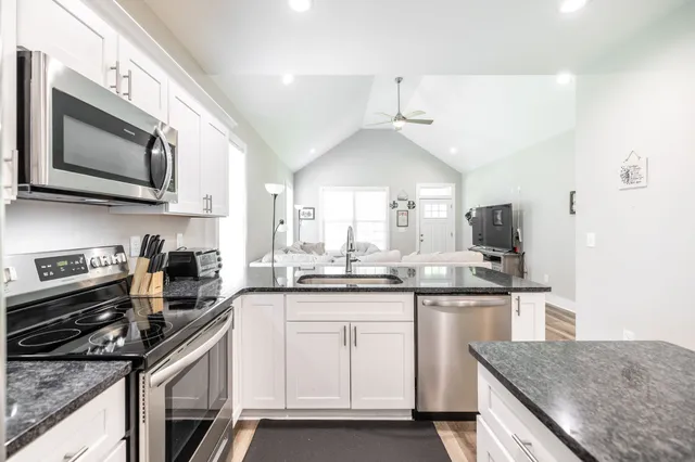 a kitchen with stainless steel appliances granite countertop a sink and stove top oven