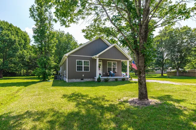 a front view of a house with yard and green space