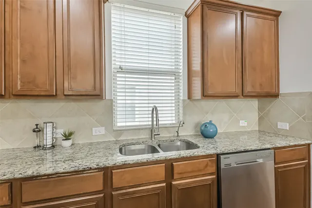 a kitchen with granite countertop cabinets sink and window