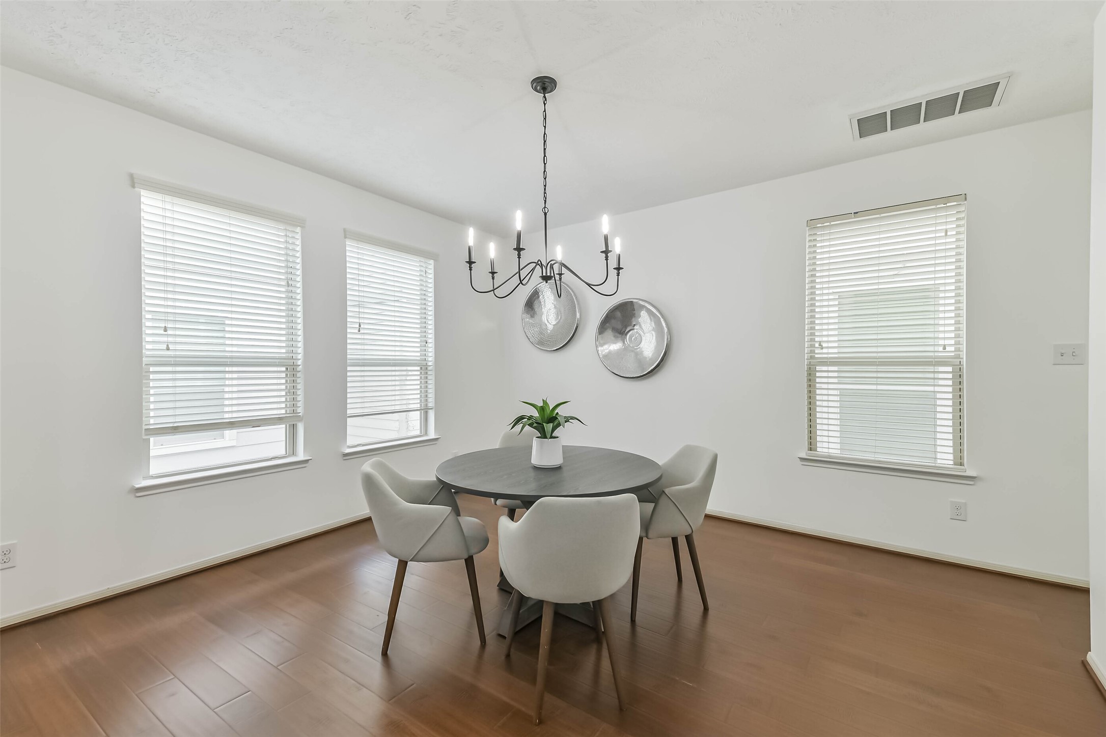 3324 Masters Point Drive Houston, TX 77091 - Photo 21 of 40 a dining room with wooden floor a chandelier a wooden table and chairs
