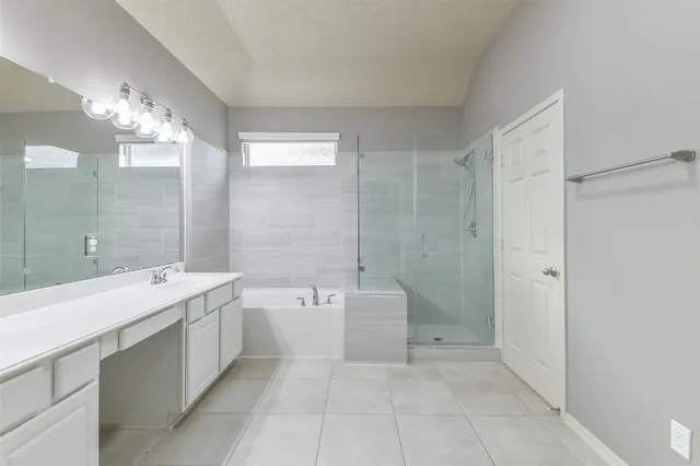 a spacious bathroom with a double vanity sink mirror and a bathtub