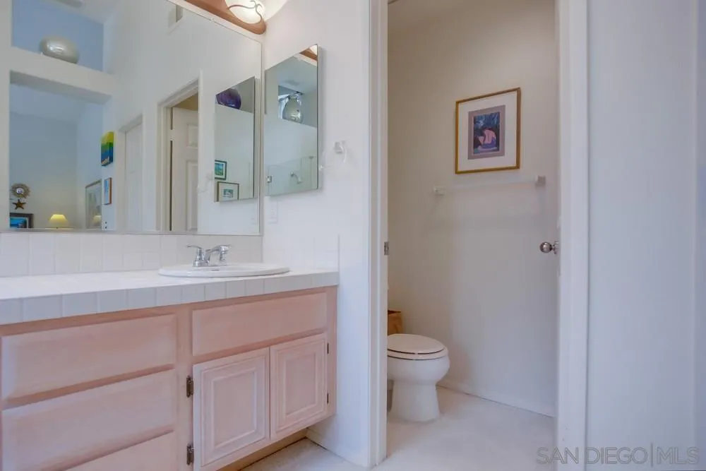 793 Poppy Road San Marcos, CA 92078 - Photo 32 of 38 a bathroom with a toilet sink and mirror