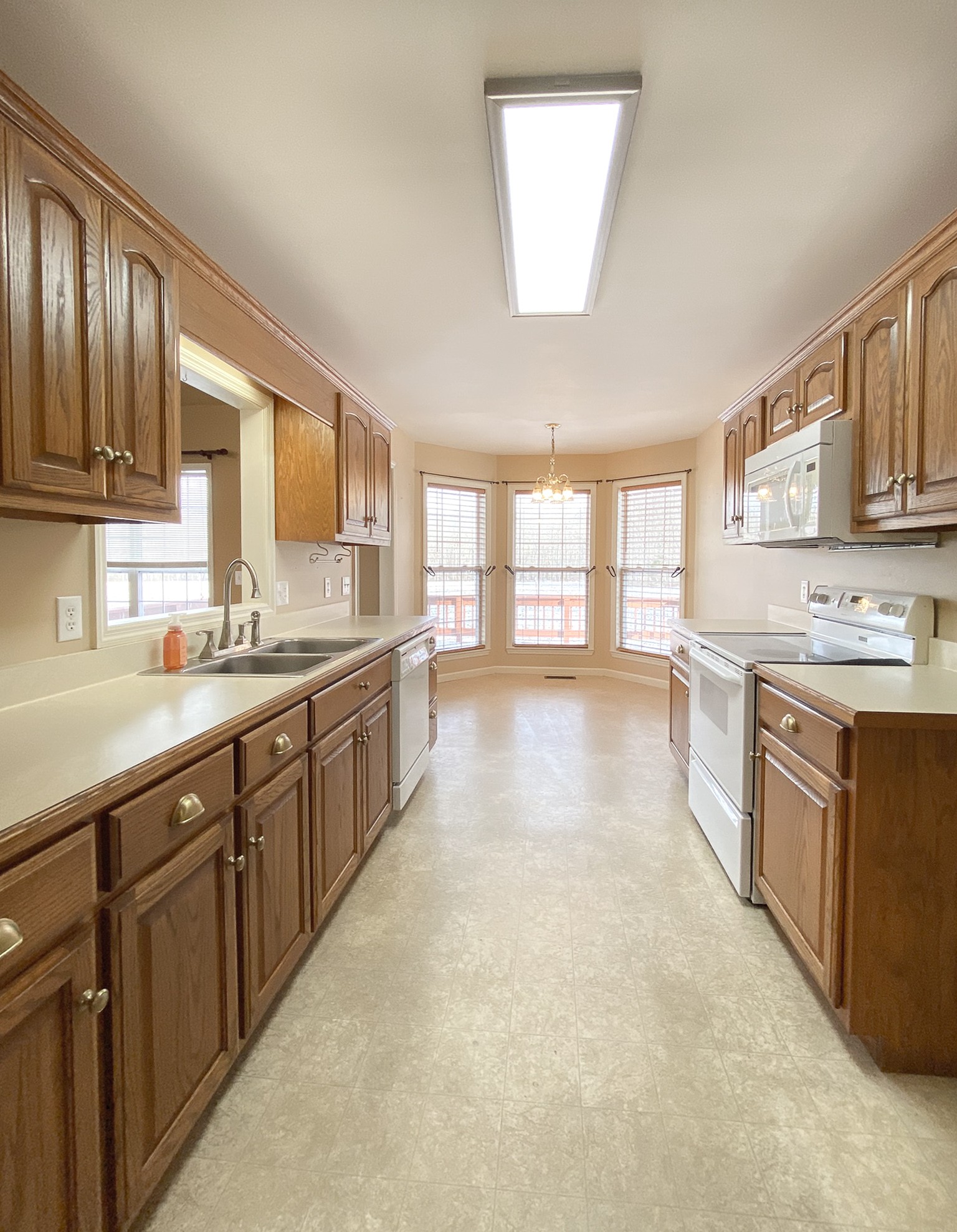 215 Falcon Drive Manchester, TN 37355 - Photo 6 of 25 a large kitchen with stainless steel appliances granite countertop a stove a sink dishwasher and a microwave oven with white cabinets