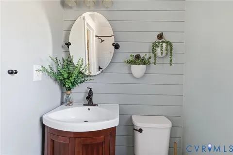 a bathroom with a sink and mirror with toilet