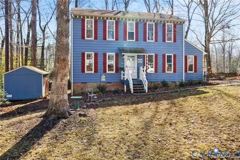 a front view of a house with yard and trees