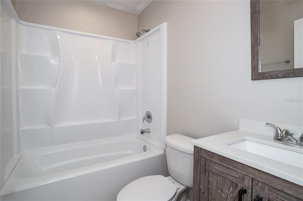 2015 Jones Avenue Sanford, FL 32771 - Photo 9 of 16 a bathroom with a granite countertop sink toilet and bathtub