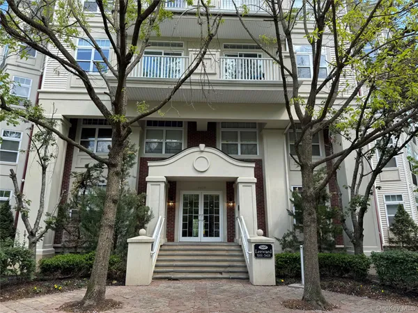 a front view of a house with a tree