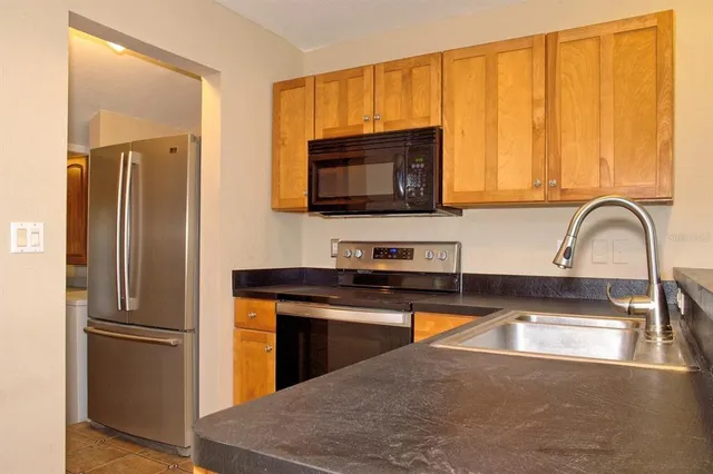 a kitchen with a sink a refrigerator and a stove top oven