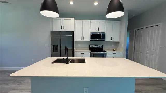 a kitchen with stainless steel appliances a refrigerator and microwave