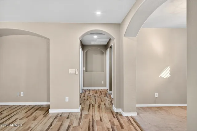 a view of a hallway with wooden floor and a bathroom