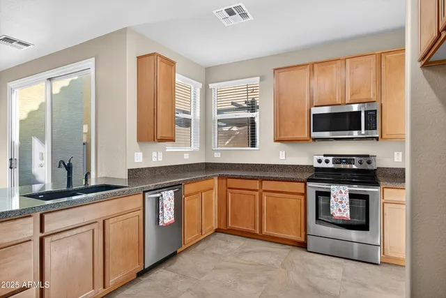a kitchen with stainless steel appliances granite countertop a stove microwave and sink