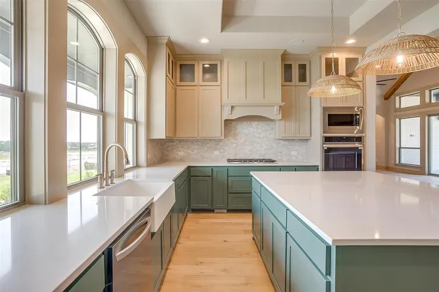 a kitchen with stainless steel appliances granite countertop a sink and dishwasher a stove top oven with wooden floor