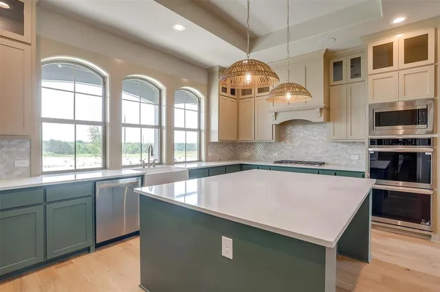 a kitchen with stainless steel appliances granite countertop a sink and a microwave