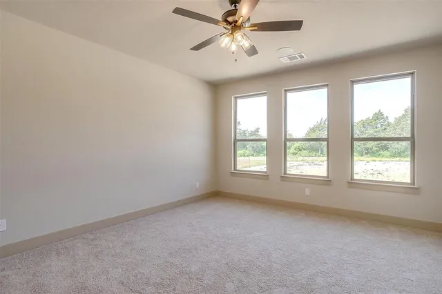 an empty room with a window and a fan