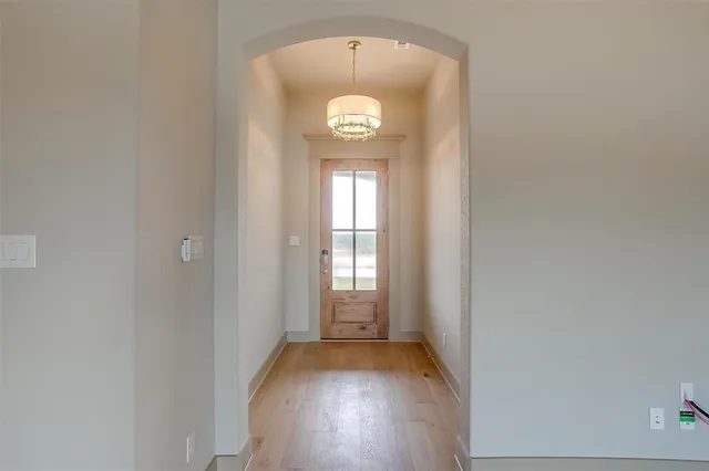 a view of a hallway with wooden floor and window