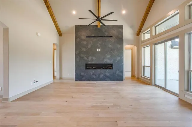 a view of an empty room with a fireplace and a window