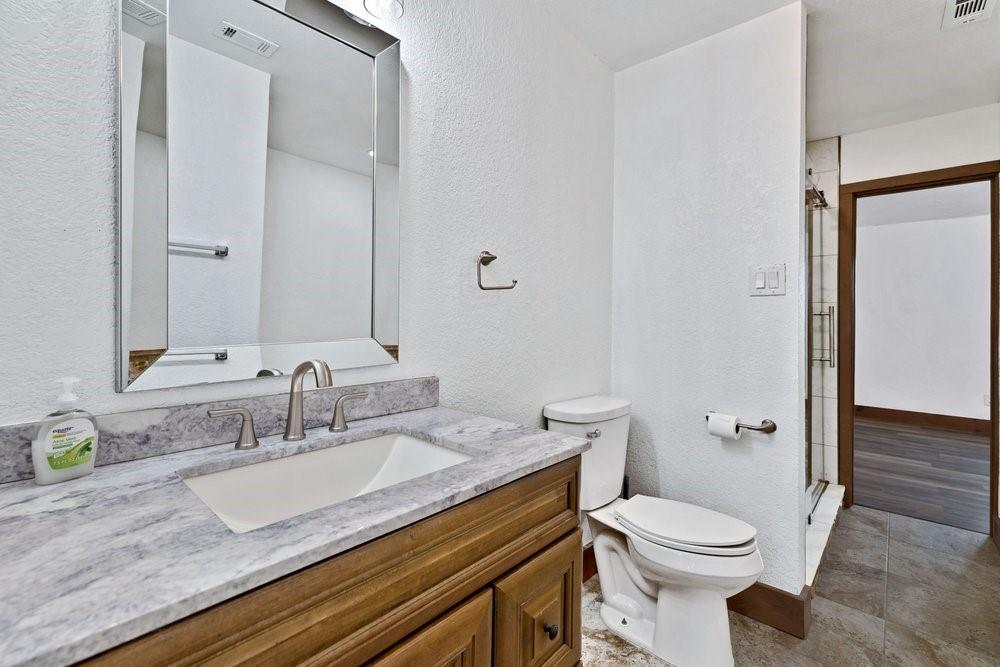 324 Rolling Oaks Ridge Cedar Hill, TX 75104 - Photo 29 of 39 a bathroom with a granite countertop toilet sink and mirror