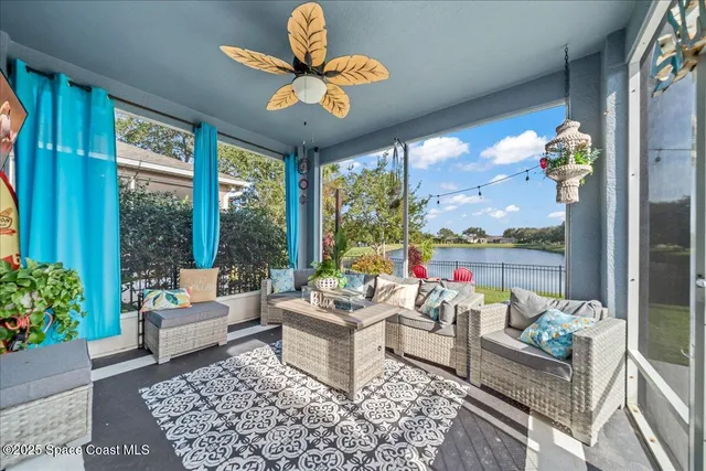 a living room with patio furniture and a large window