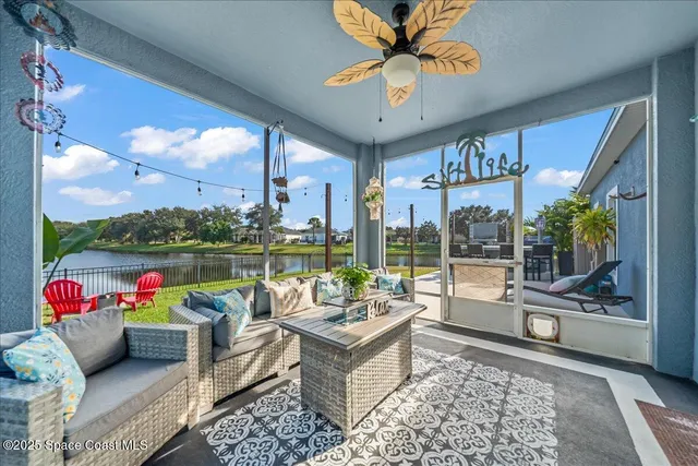 a living room with patio furniture and a floor to ceiling window