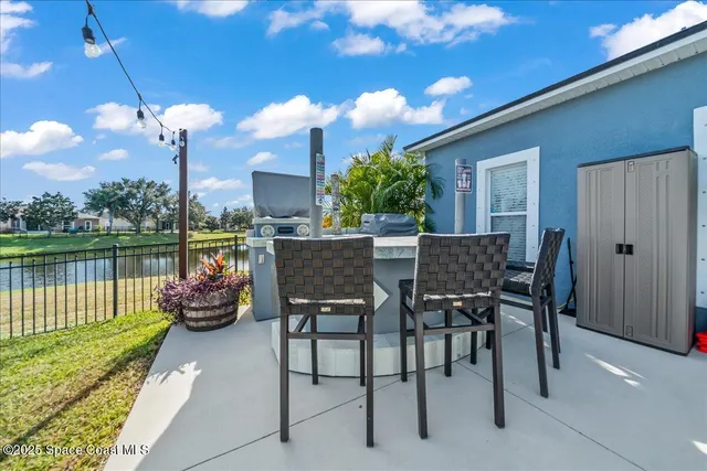 a view of a patio with a table chairs and a backyard