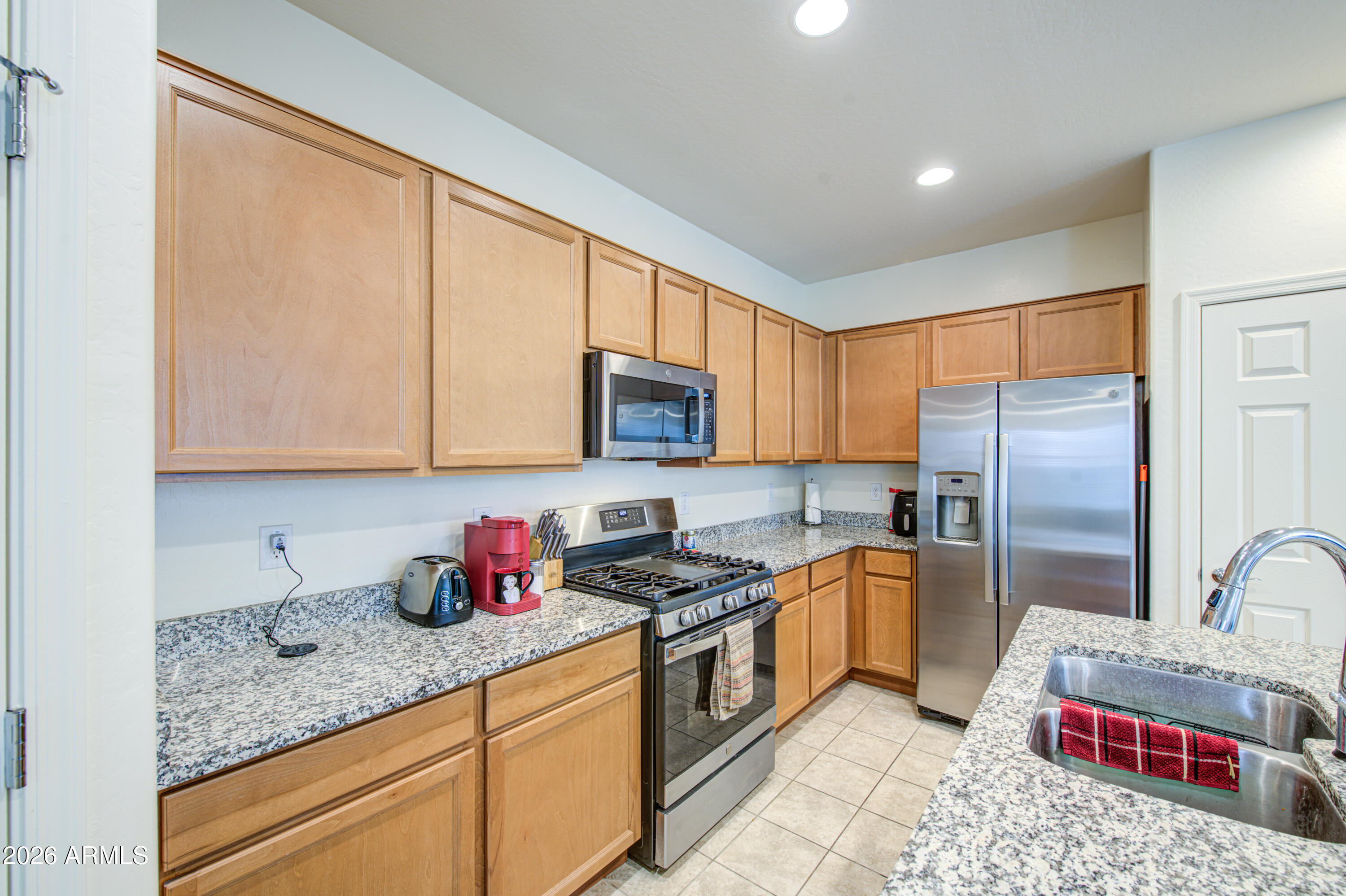 1705 South 83rd Way Mesa, AZ 85209 - Photo 14 of 39 a kitchen with stainless steel appliances granite countertop a sink refrigerator and microwave