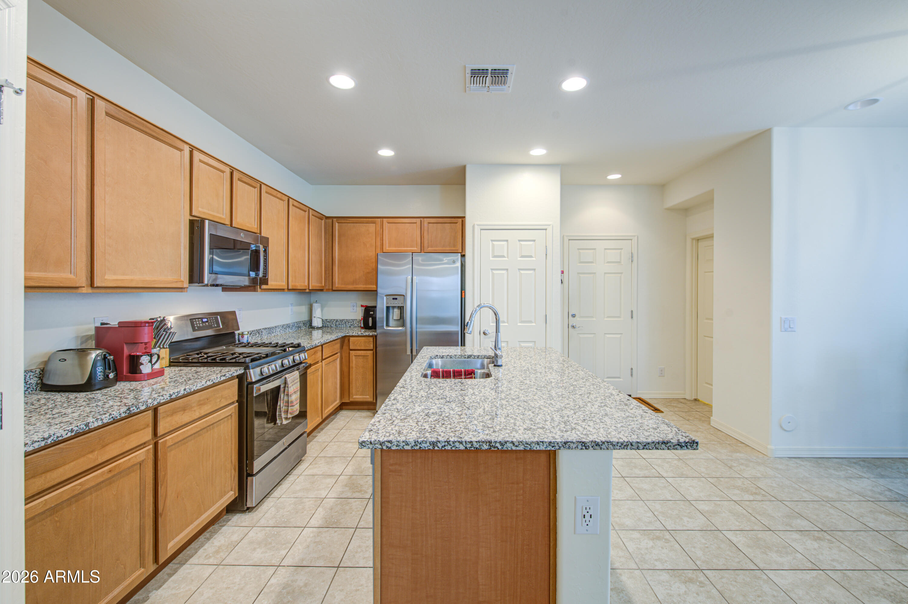 1705 South 83rd Way Mesa, AZ 85209 - Photo 10 of 39 a kitchen with stainless steel appliances granite countertop a sink dishwasher stove top oven and cabinets with wooden floor