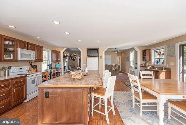 a bathroom with a granite countertop sink a toilet and a shower