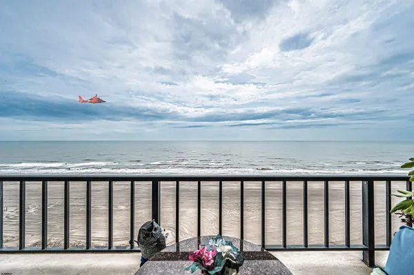 a room with lots of tables a large window and chairs