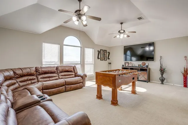 a living room with furniture a chandelier and a flat screen tv
