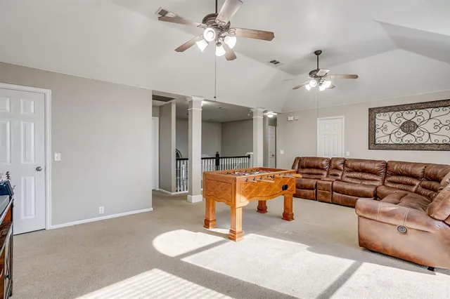 a living room with furniture a ceiling fan and a rug