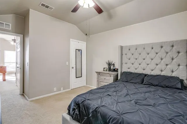 a bedroom with a bed and a lamp on dresser