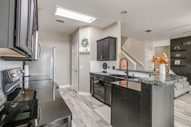 a kitchen with stainless steel appliances granite countertop a sink stove and refrigerator