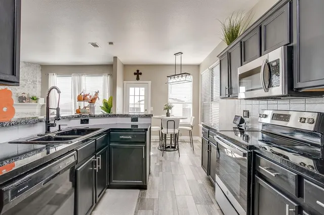 a kitchen with stainless steel appliances a sink stove and cabinets