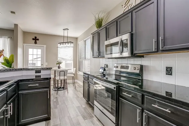 a kitchen with stainless steel appliances a stove sink microwave and cabinets