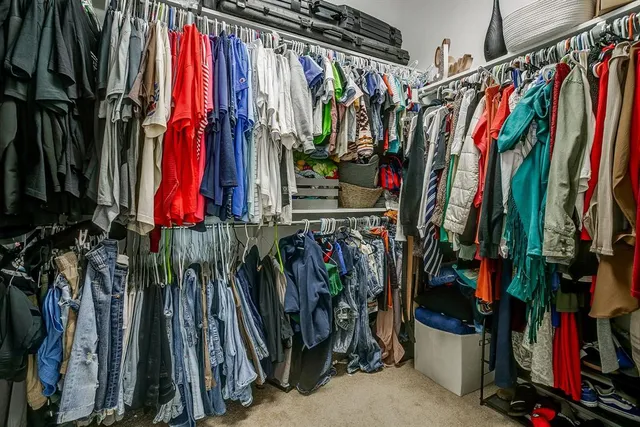 a view of walk in closet with clothes