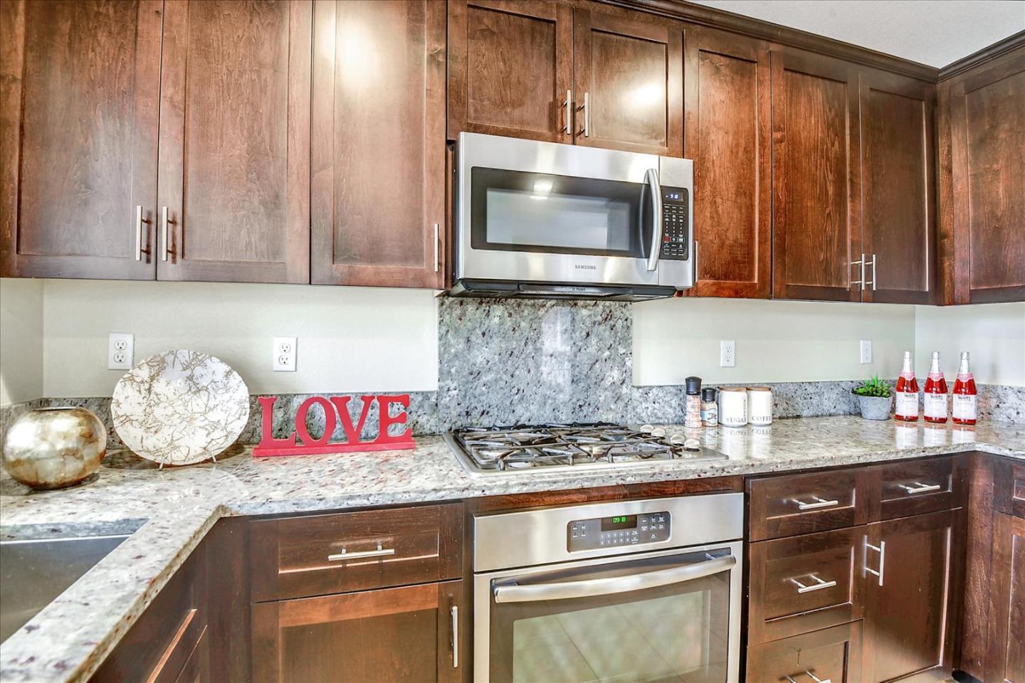 2038 Trento Loop Milpitas, CA 95035 - Photo 6 of 22 a kitchen with granite countertop stainless steel appliances wooden cabinets and a stove top oven