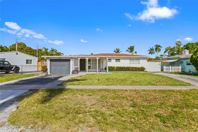 a view of house with swimming pool and yard