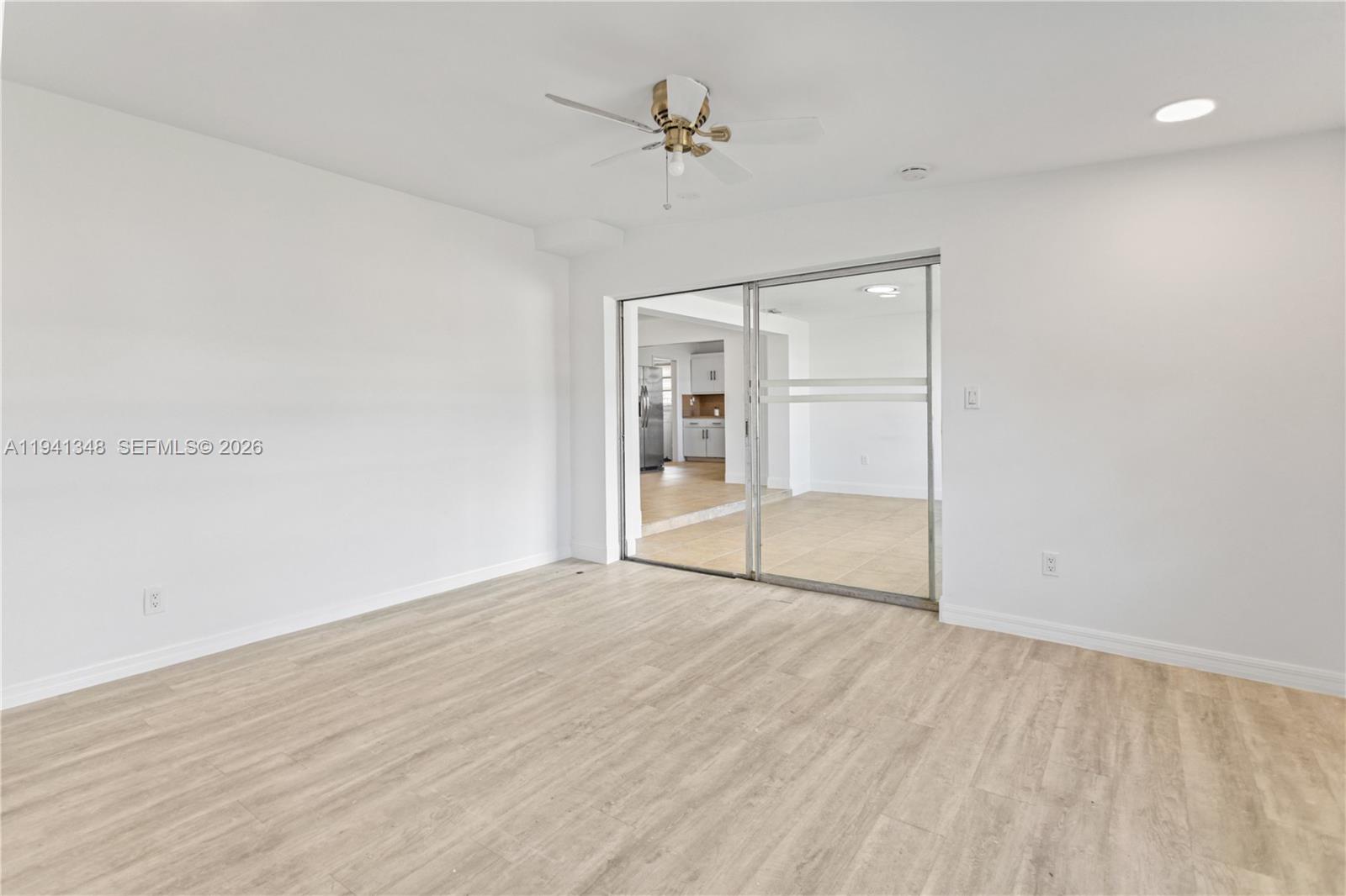 3253 Pierce Street Hollywood, FL 33021 - Photo 38 of 53 an empty room with wooden floor chandelier fan and windows