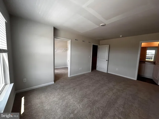 an empty room with windows and closet