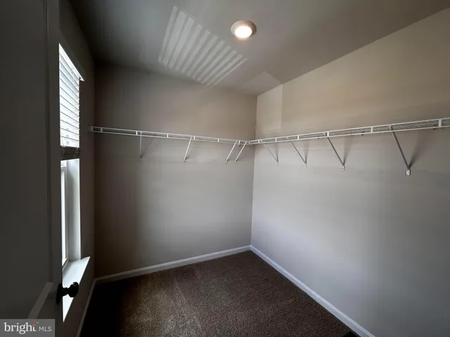 an empty room with a wooden floor and windows