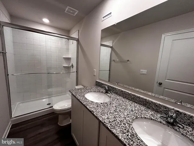 a bathroom with a granite countertop sink toilet and shower