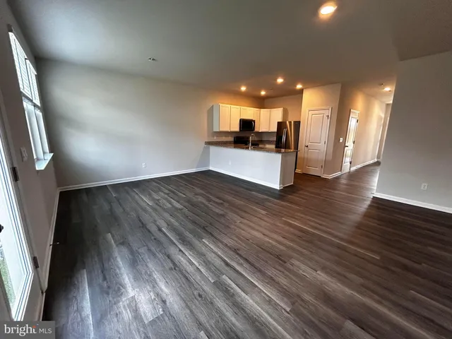 an empty room with wooden floor and entrance