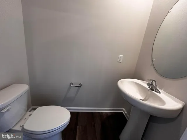 a bathroom with a sink mirror and toilet