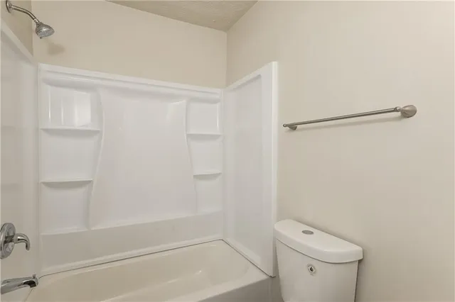 a bathroom with a shower a toilet and a sink